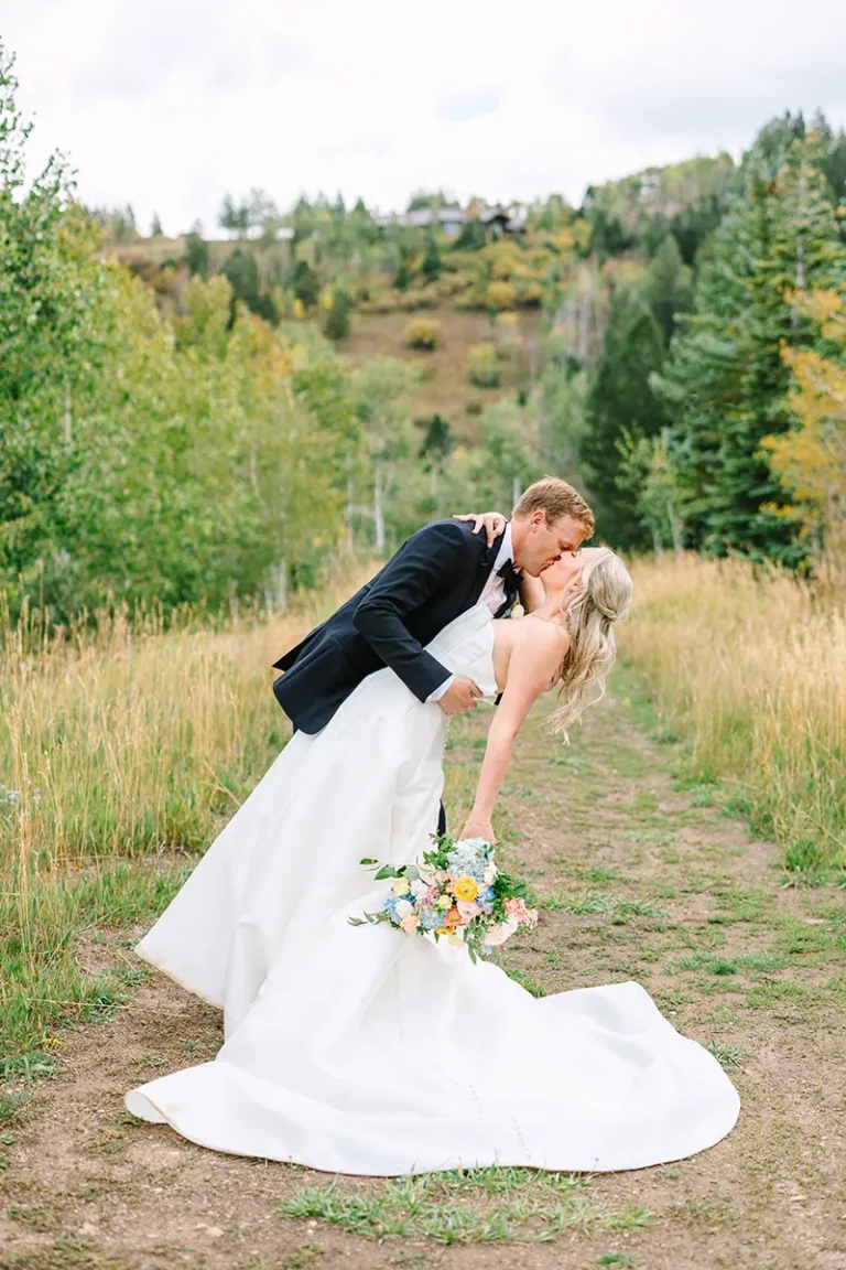 wedding groom dipping bride and kissing at bachelor gulch in vail colorado